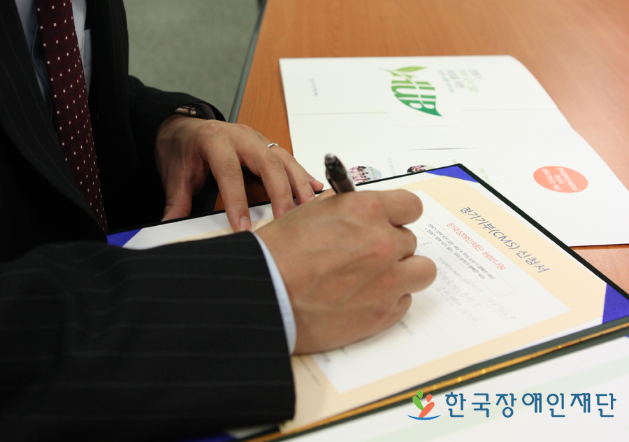 익명의 기부자가 기부약정서를 쓰고 있는 모습